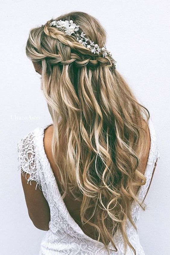 La delicadeza de las trenzas y la naturalidad de las ondas al aire se unen en un peinado adornado con tocado perfecto para novias 'boho (Foto: Pinterest).