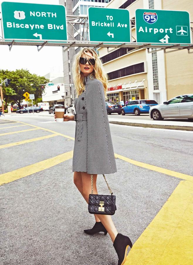 Capa con estampado de pata de gallo, bolso y botines, todo de Dior. Las gafas de sol son de Pierre Cardin.