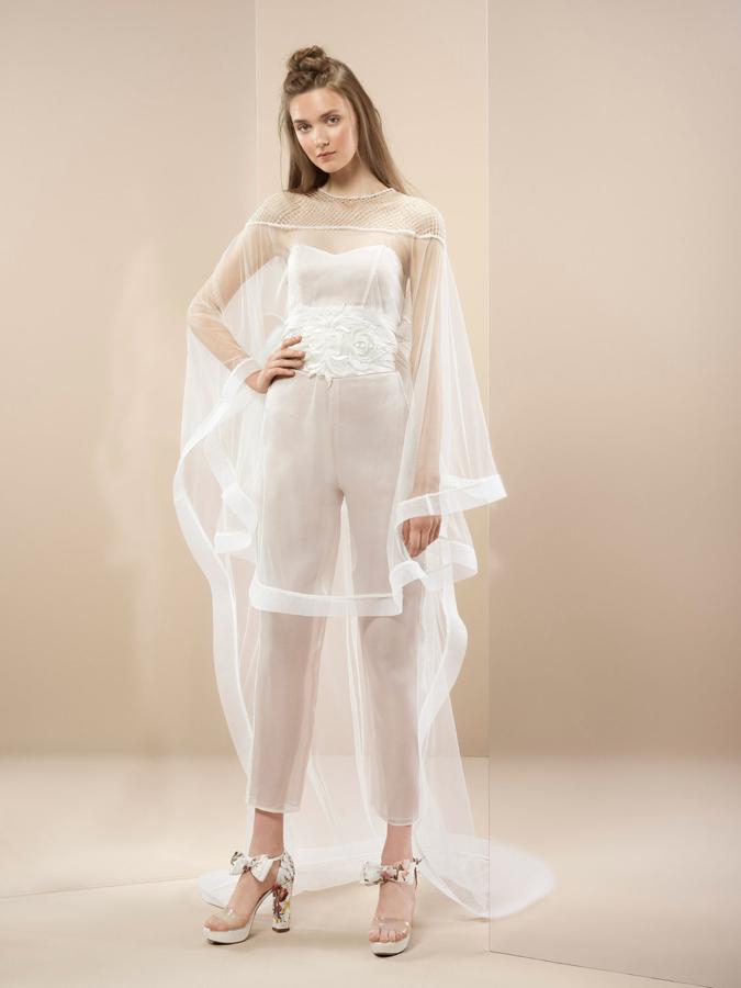 Corpiño de seda y pantalón semi-transparente con cinturón drapeado y un gran lazo en organza de seda. Completa el estilismo un poncho sedoso de pedrería.