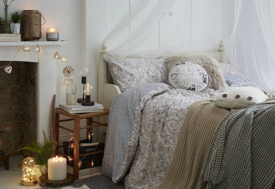 Los tonos neutros se combinan con acogedoras mantas de punto, y la madera y las velas añaden un punto extra de calidez al ambiente.