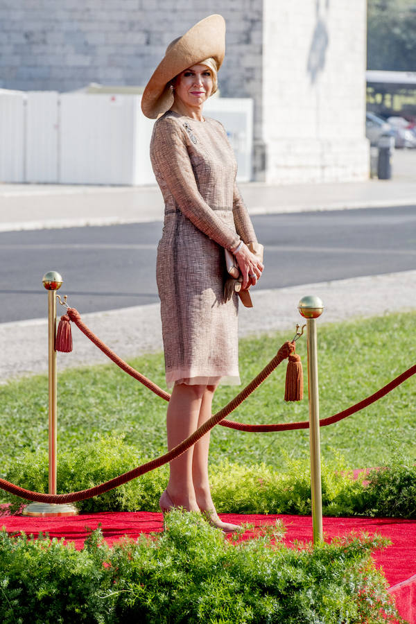 Para su primer día en Portugal, Máxima de Holanda apostó por un sencillo y elegante vestido en tonos tierra de una de sus firmas favoritas, la belga Natan. Completó el look con una de sus pamelas XXL de Fabienne Delvigne.