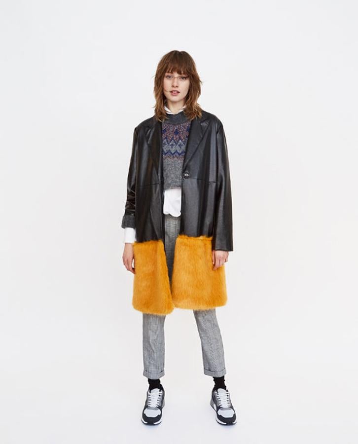 Abrigo efecto piel con bajo de peluche de Zara. Precio sin descuento: 59,95 euros.