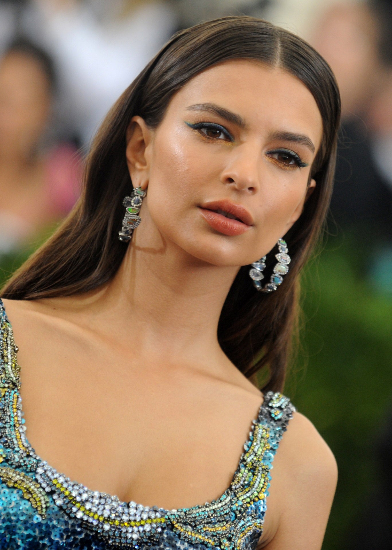 La modelo y actriz Emily Ratajkowski luce pendientes maxi con la melena suelta con raya en el medio y textura en las raíces.