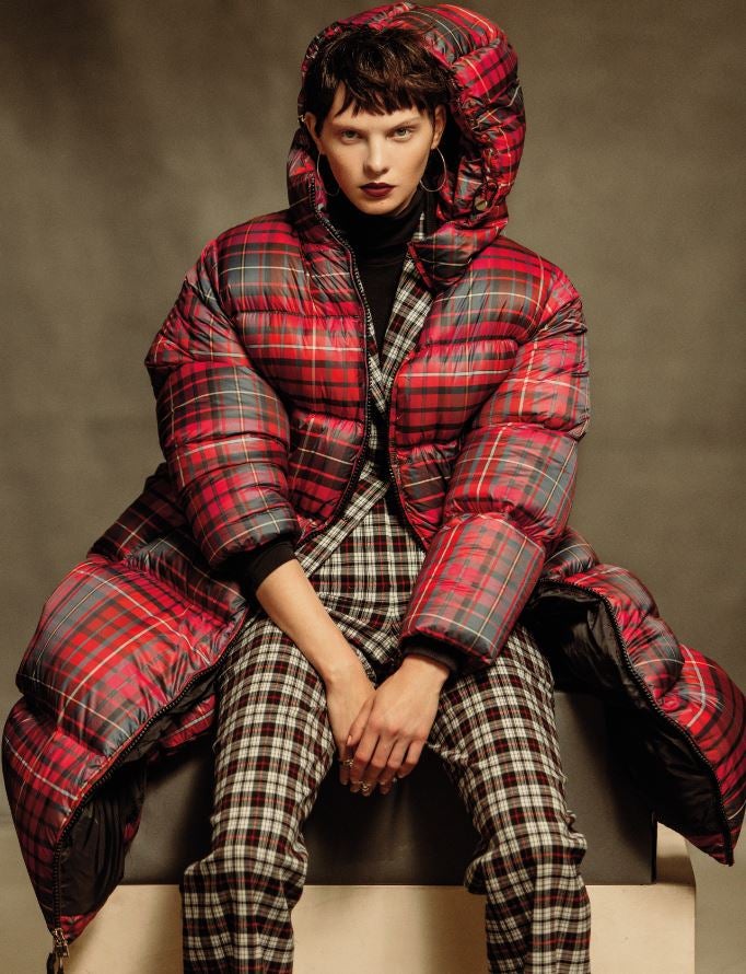 Un plumas de Tommy Hilfiger Collection cubre el traje sastre de George Rech Paris y el top de cuello vuelto, de Wolford. Los anillos son de Tiffany & Co y los pendientes, de Tous