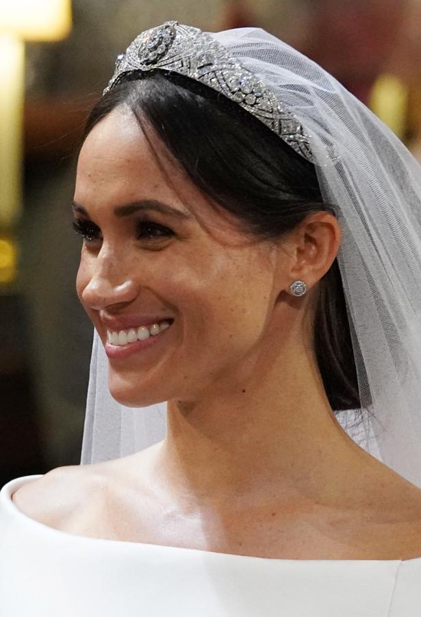 Meghan Markle ha apostado por un maquillaje muy natural y un favorecedor recogido bajo sobre el que caía el impresionante velo de tul bordado y que se coronaba con la maravillosa tiara Filigree.