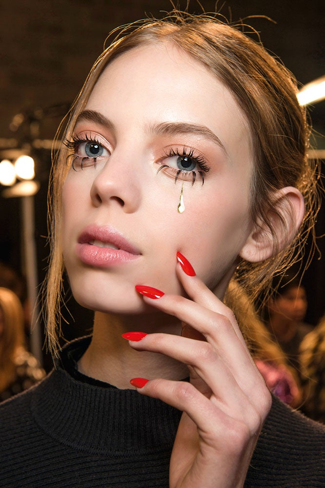 La propuesta definitiva de Jeremy Scott para las fiestas. Maquillaje natural, un adhesivo en forma de lágrima, pestañas hiperlargas y uñas de color intenso.
