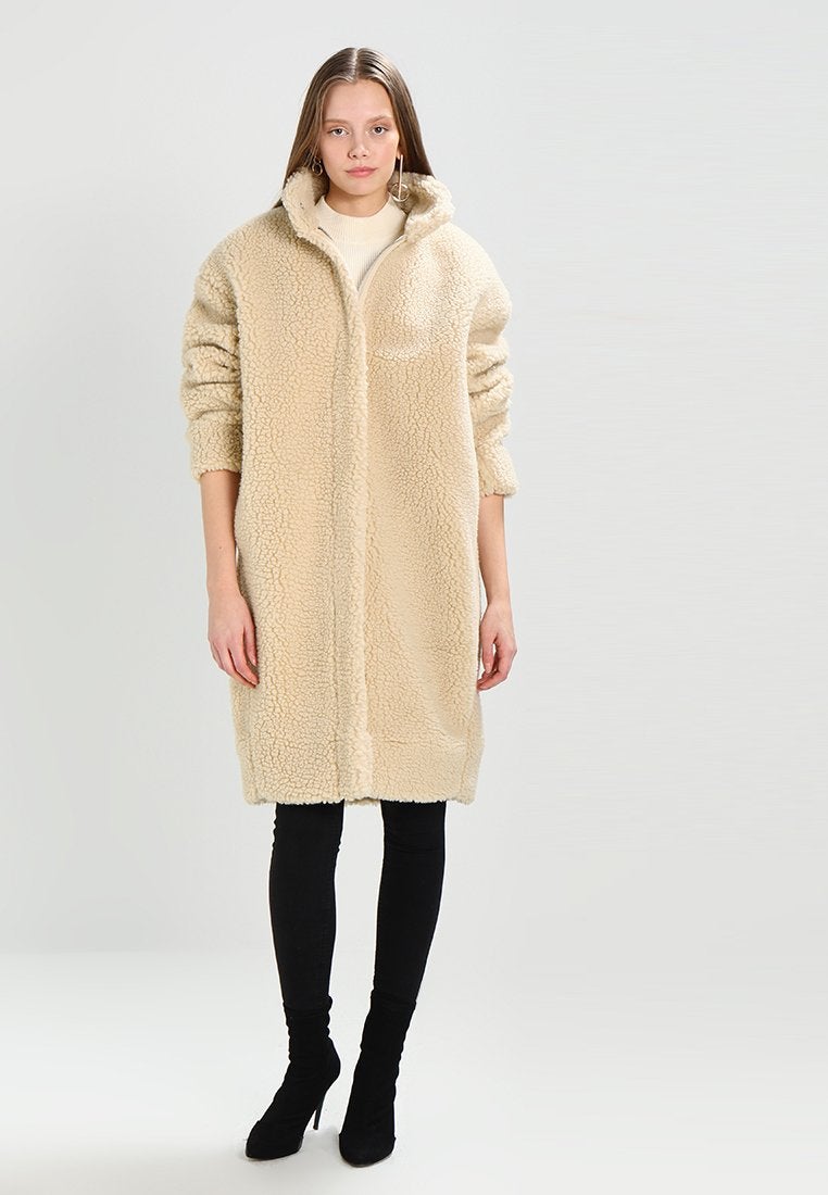 Abrigo Teddy color crudo de Weekday. Precio: 139,95 euros.