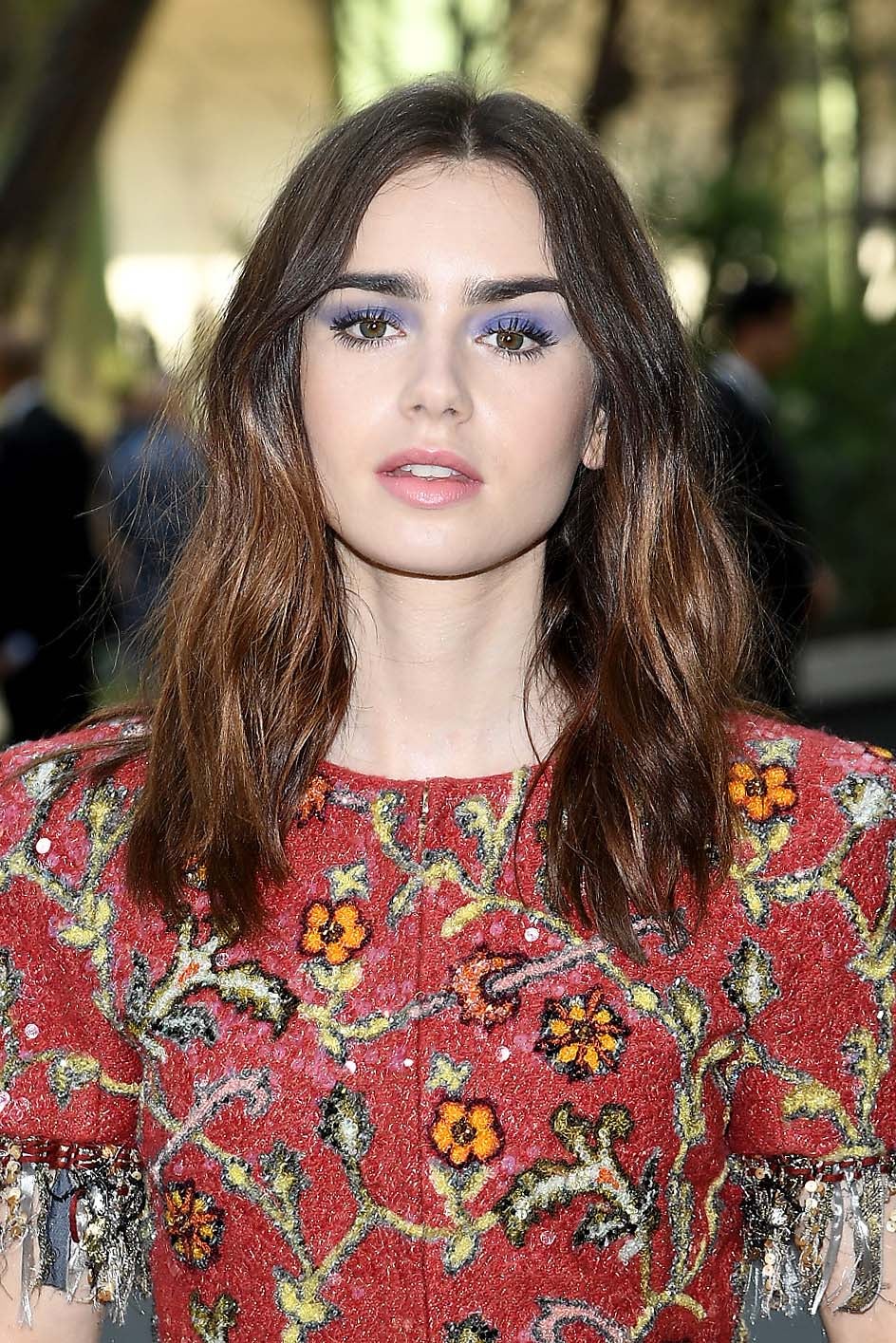 Lily Collins con sombras azules y labios rosas y una piel de porcelana en la Semana de la Alta Costura de París.