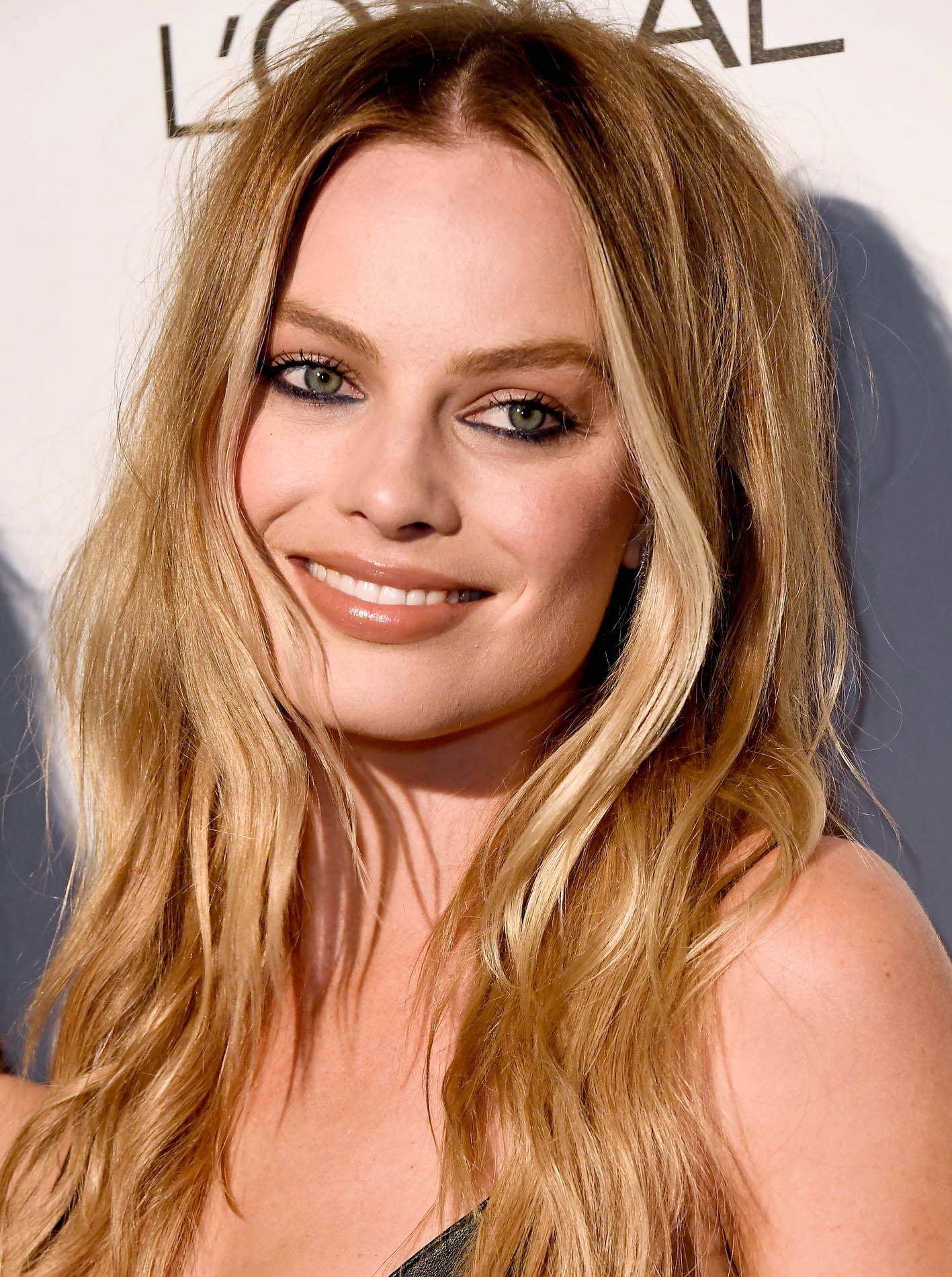 Margot Robbie con un bonito maquillaje en tonos nude en ojos y labios que contrastaba con el eyeliner en la línea de agua en azul oscuro.