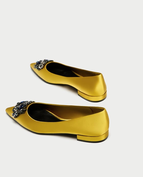 Bailarinas de satén amarillo con detalle joya de Zara. Precio: 39,95 euros.