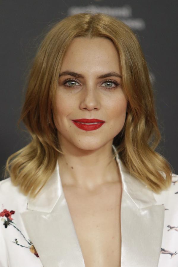 Aura Garrido también dejó su melena suelta, pero con raya en el medio y una onda en las puntas. En cuanto al maquillaje, labios rojos mates.