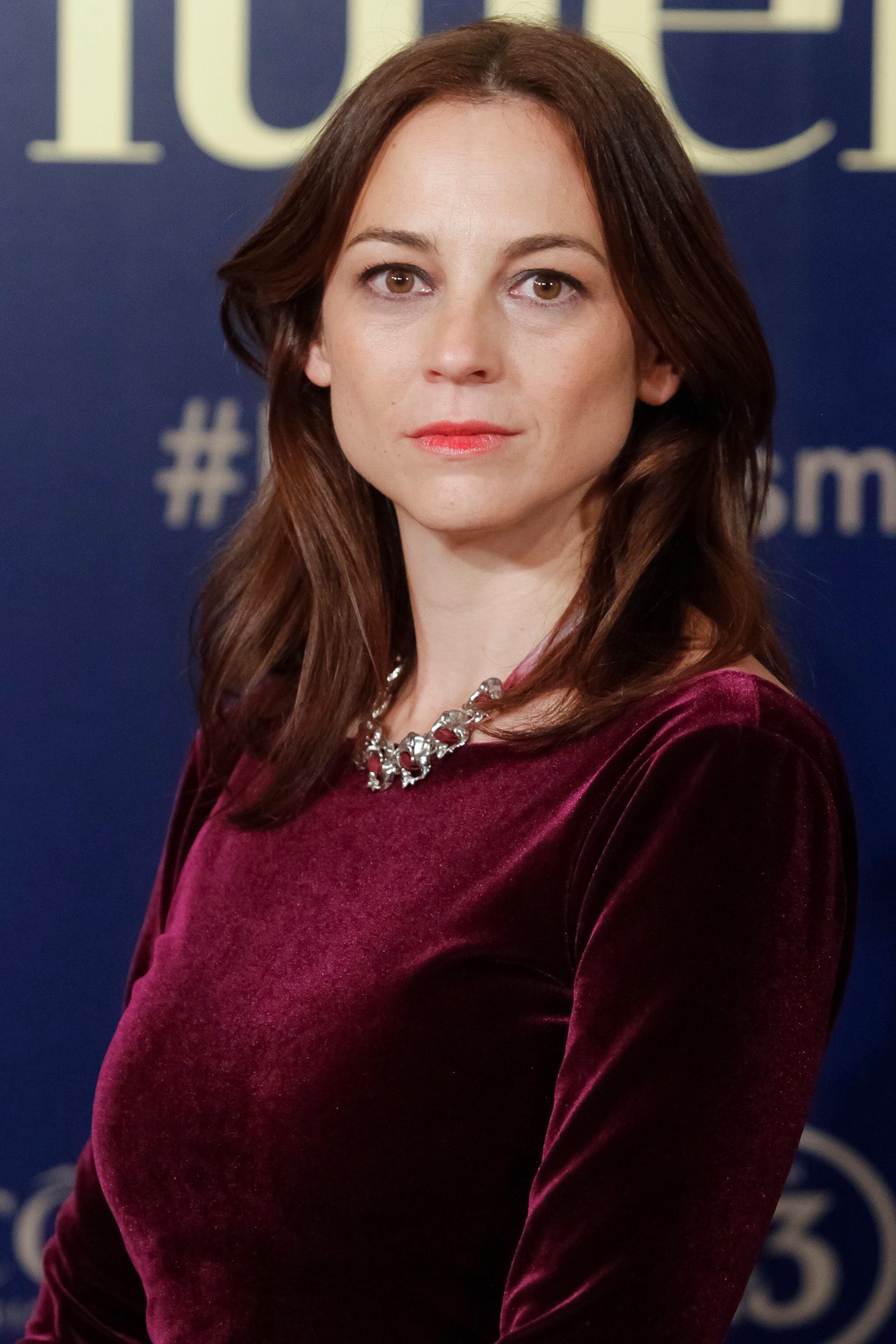 Leonor Watling con melena suelta con ondas abiertas y raya en el medio y un discreto maquillaje con eyeliner negro y gloss rosado.