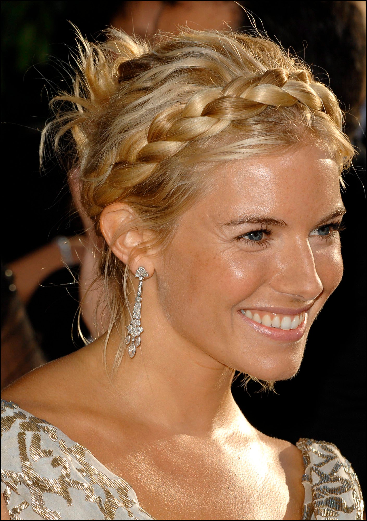 Sienna Miller con un moño informal con mechones sueltos y trenza en corona. Otro peinado romántico que puedes copiar.