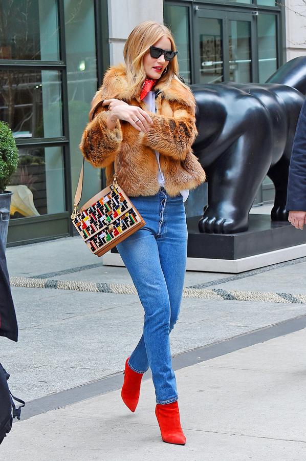 El vaquero y la camiseta funcionan siempre. Para que fuera más sofisticado, Rosie Huntington los conjuntó con unos botines rojo, chaqueta de pelo y bandana al cuello