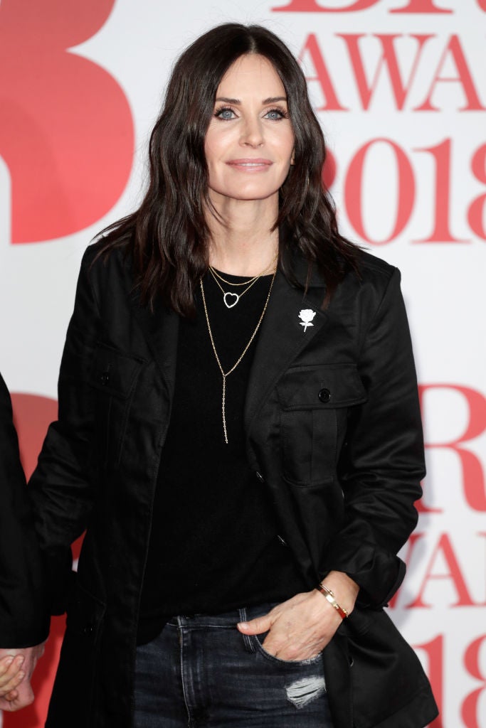 ¿Vaqueros en la alfombra roja? Esa ha sido la apuesta 'effortless' en negro de Courtney Cox, que los ha combinado con sahariana negra de Saint Laurent. Su rosa del 'time's up', un broche en la solapa.