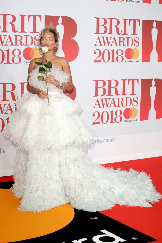 Rita Ora, excesiva pero perfecta con un impresionante vestido blanco de plumas de Ralph&Russo. Entre las manos, su rosa blanca.¿El blanco es el nuevo negro feminista del 'time's up'?