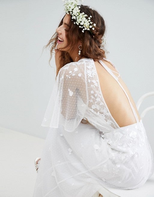 Vestido blanco de plumetti con flores y escote en la espalda de Asos. Precio: 116,99 euros.