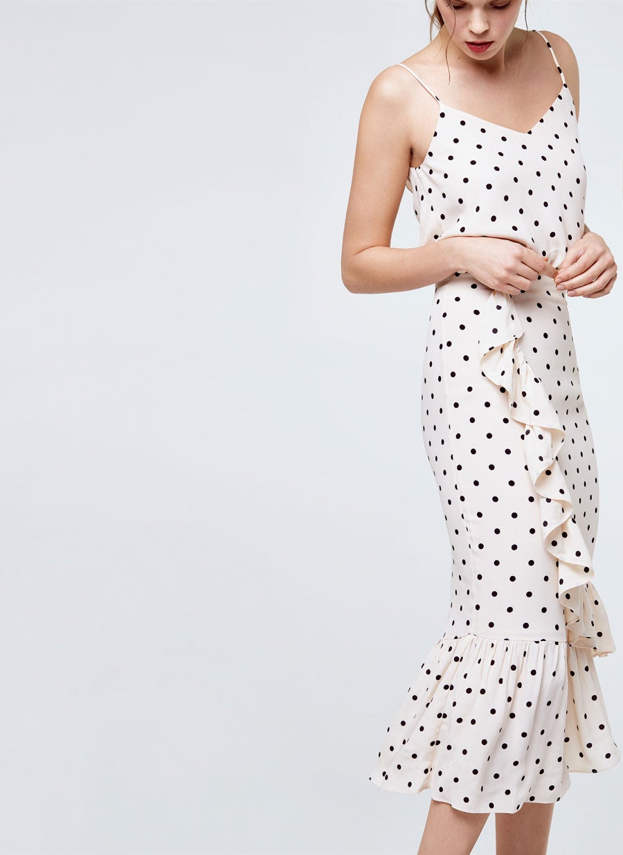 Vestido blanco de lunares y volante al bies de Uterqüe. Precio: 79 euros.