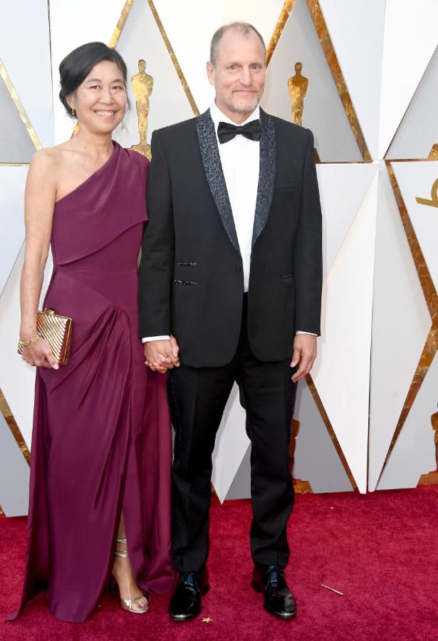 Laura Louie y Woody Harrelson posan en la alfombra roja de los premios Oscar.