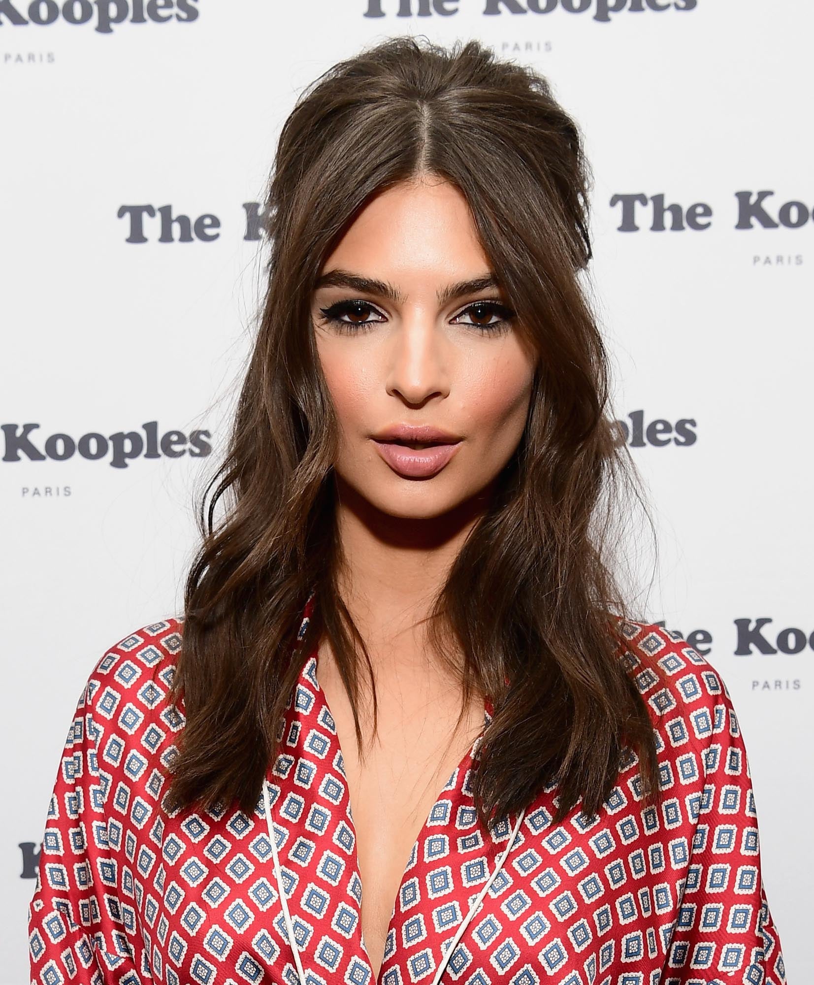Si te gusta el look 'sixties' a lo Brigitte Bardot, copia el peinado de Emily Ratajkowski, semirrecogido con raya en el medio, volumen en la coronilla y ondas ligeras.
