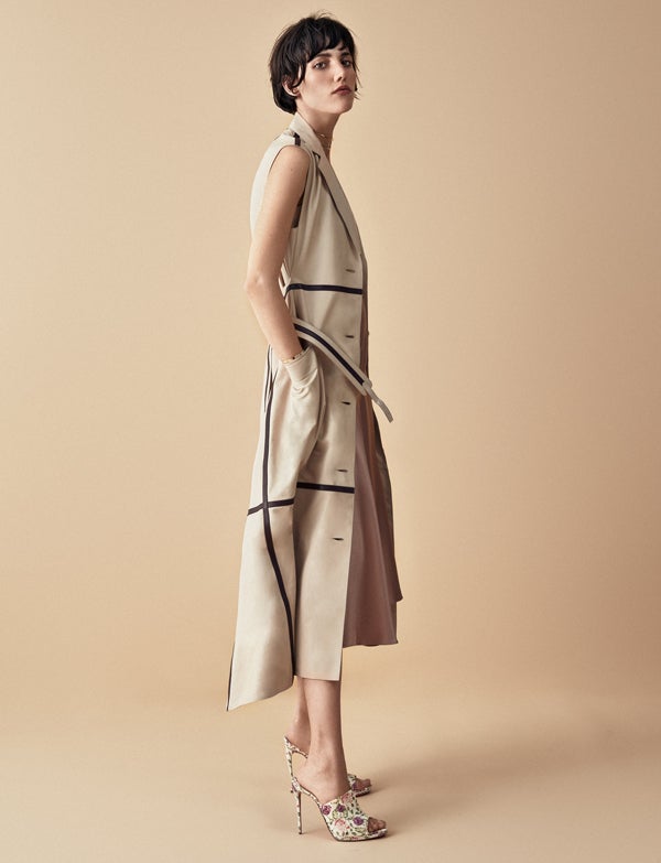 Trench de Hermès, top de Betolaza Studio y falda de Salvatore Ferragamo. Sandalias de Christian Louboutin, choker y brazalete de Messika, y anillos de Aristocrazy.