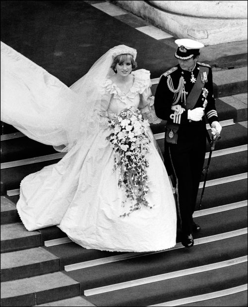 El vestido de Camilla Parker-Bowles puede ser leído como una metáfora de la propia historia de amor de esta mujer no precisamente amada por la ciudadanía británica con el heredero de la corona británica: sorprendentemente, logra que nos olvidemos de todos los problemas. La genialidad de recurrir a ese magnífico tocado de plumas doradas convierte la consabida tiara en una intrascendencia insípida, mientras que la diseñadora Anna Valentine maravilla con su visión de cómo debe ir vestida una futura princesa que ya no cumple los 50. Camilla lleva un abrigo de damasco azul y dorado sobre un vestido de chiffon que no puede ser más favorecedor.
