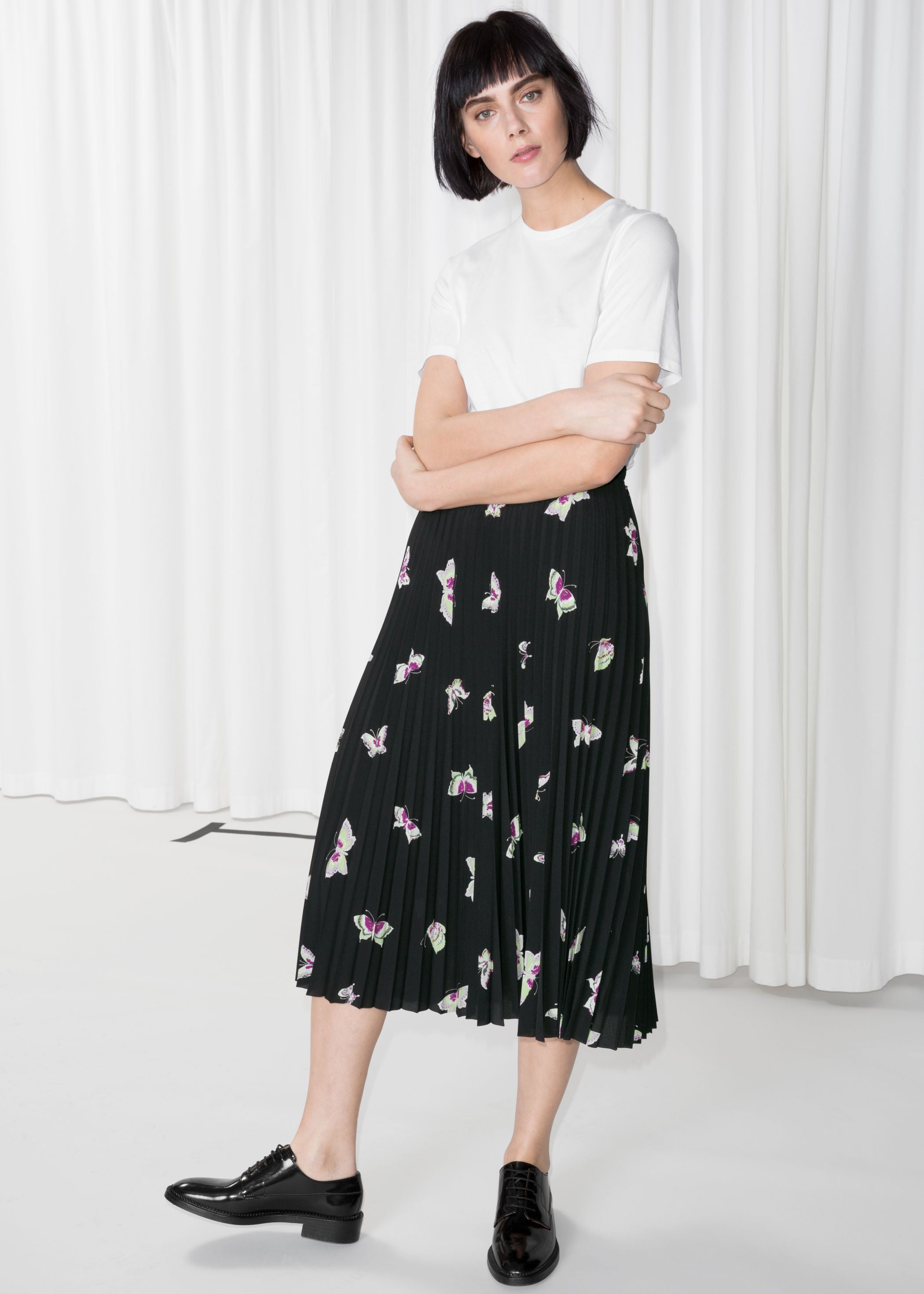 Falda midi negra, plisada y estampada de & Other Stories: 69 euros.