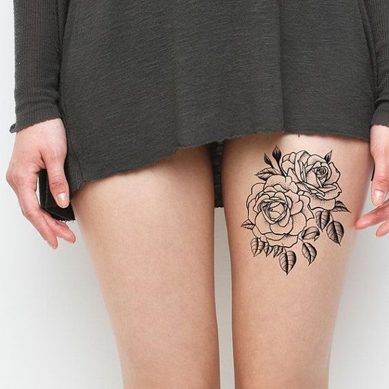 Chica con tatuaje floral en el muslo.