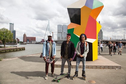 Unos chicos ante el puente Erasmo y escultura de Henk Visch.