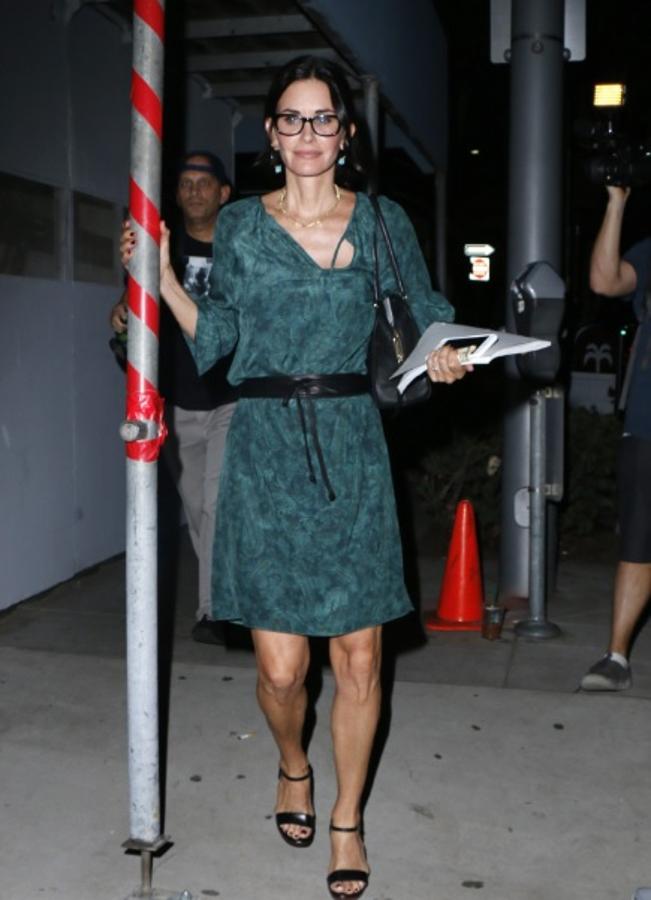 Courtney Cox no deja de lado su estilo casual como este vestido en tonos verdes acompañado por unas elegantes sandalias de tacón en color negro a juego con su bolso.