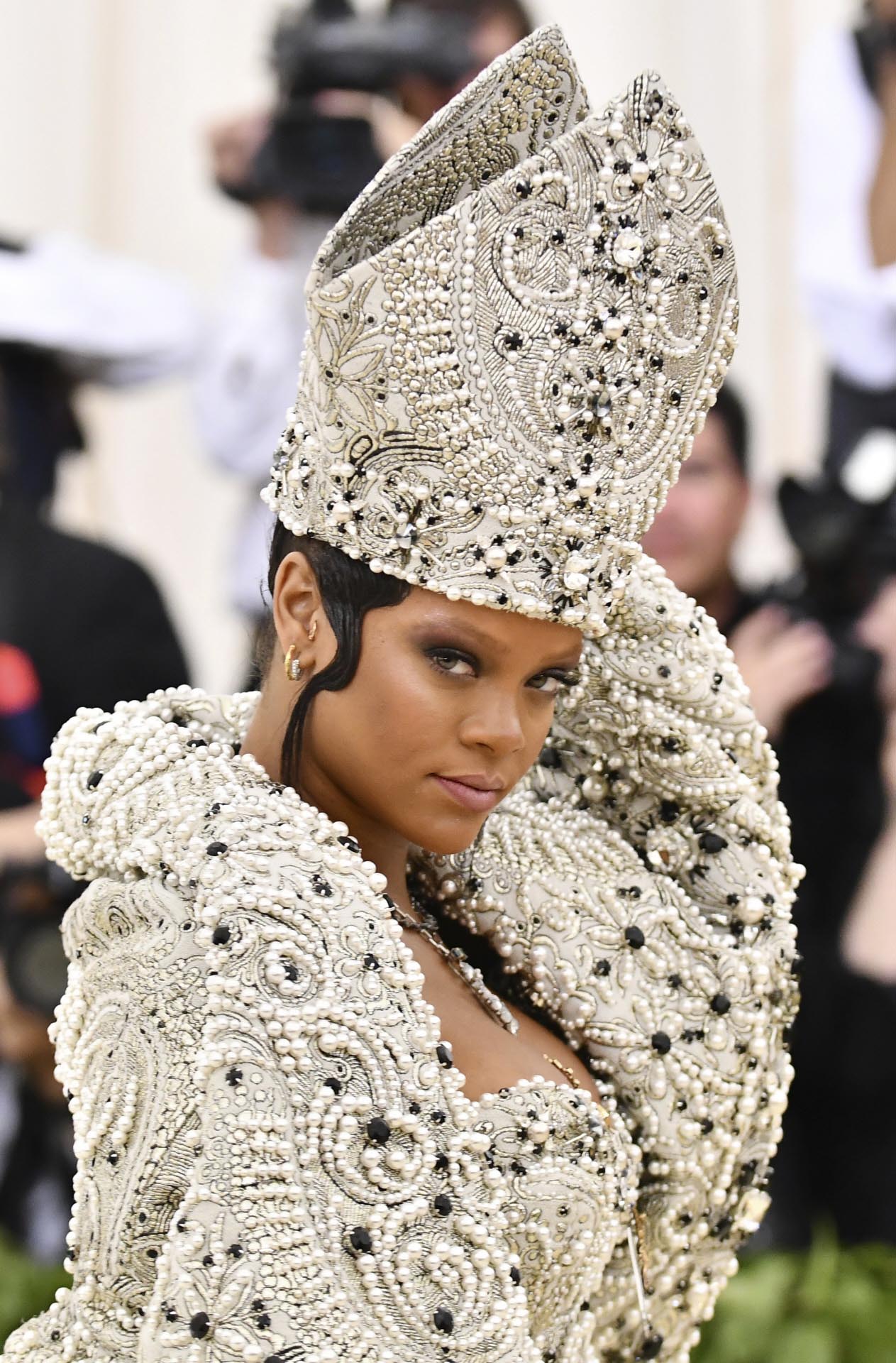 Otro de los tocados más excéntricos de la Gala Met 2018 es, sin duda, el de Rihanna. La cantante ha lucido el típico gorro de los obispos, conocido como mitra: un bonete en forma cónica de perlas y piedras negras.