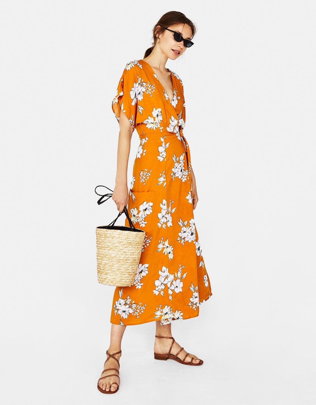 Vestido cruzado de Bershka (29,99 euros) de color naranja con flores blancas.