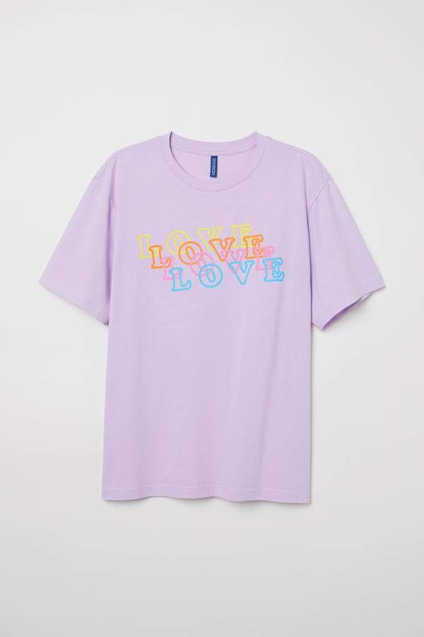 El lila es otro de los colores favoritos del colectivo LGBT. Esta camiseta lleva la palabra love en un diseño muy ochentero.