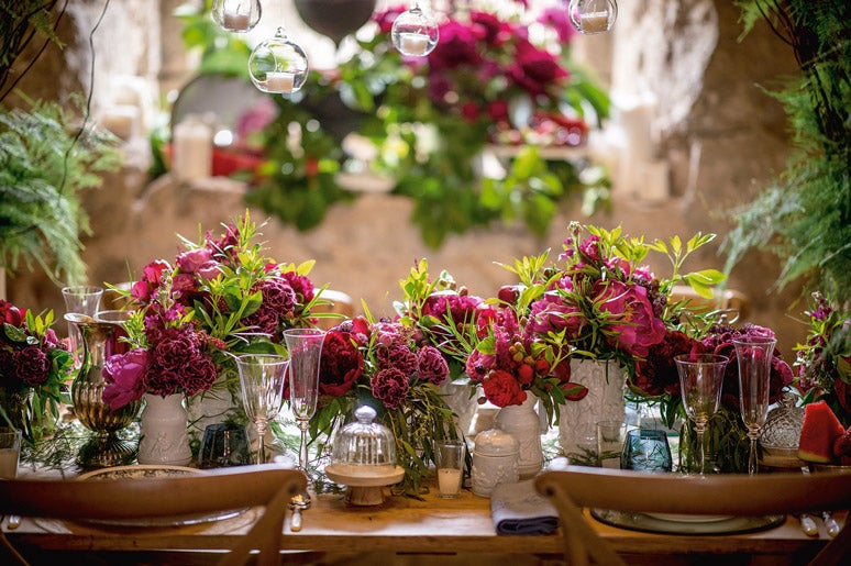 Para la decoración de las mesas, Laura Ruano Gamella, de Naranjas de la China, propone infinitos caminos textiles. En ellos, las porcelanas pintadas a mano se alternan con frutas frescas y, por supuesto, con flores de colores ácidos y cítricos, acompañados de tonalidades magentas, fucsias y frambuesas.