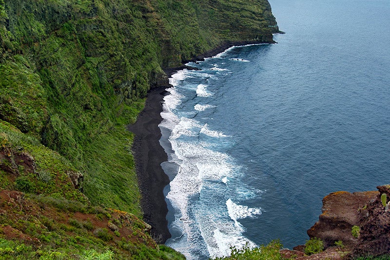 La playa de Nogales está situada en La Palma, la isla bonita de Canarias. Un paraje virgen y salvaje de colores verdes intensos que contrasta con la arena negra volcánica que tanto caracteriza a la identidad de las islas. Probablemente una de las playas escondidas más bonitas de todo el planeta.