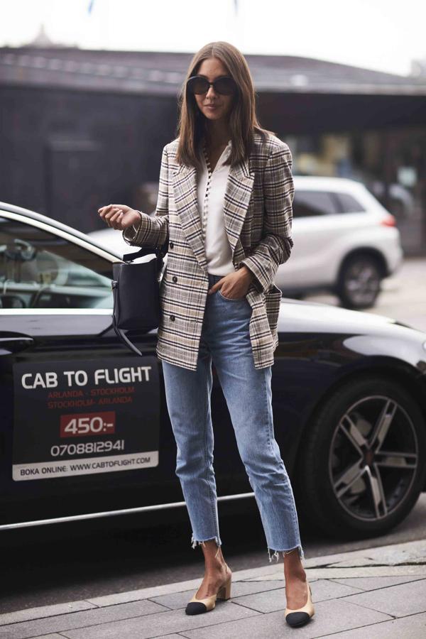 El clásico fondo de armario: vaqueros y blusa blanca que casan a la perfección con una prenda de cuadros. ¿Un pequeño gesto que marcará la diferencia? Cambia el bolso negro por uno de color.