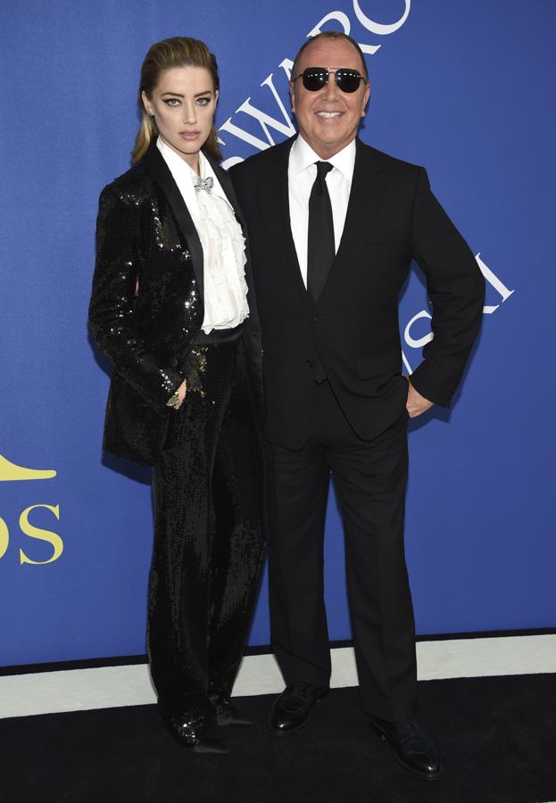 Amber Heard acudió elegantísima acompañada de Michel Kors, que firma el impecable esmoquin de lentejuelas que lució la modelo.