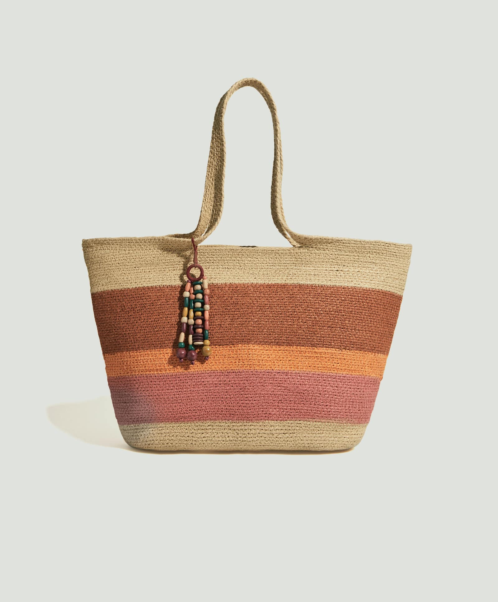 Este año hay cientos de bolsos para ir a la playa, pero este en concreto nos ha gustado mucho con el detalle de los colores y el detalle de los abalorios. De Oysho por 29,99 euros.