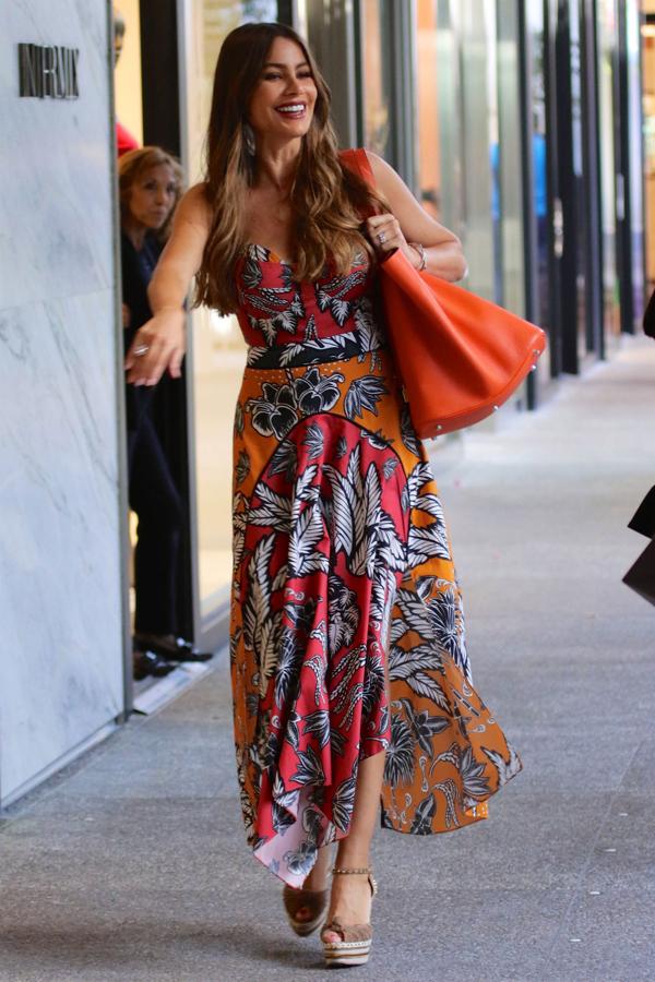 Sofía Vergara perfecta con este vestido largo de diseño tropical, unas cuñas en color marrón y bolso a juego con el vestido. Un 'look' fresco y super alegre perfecto para este verano.
