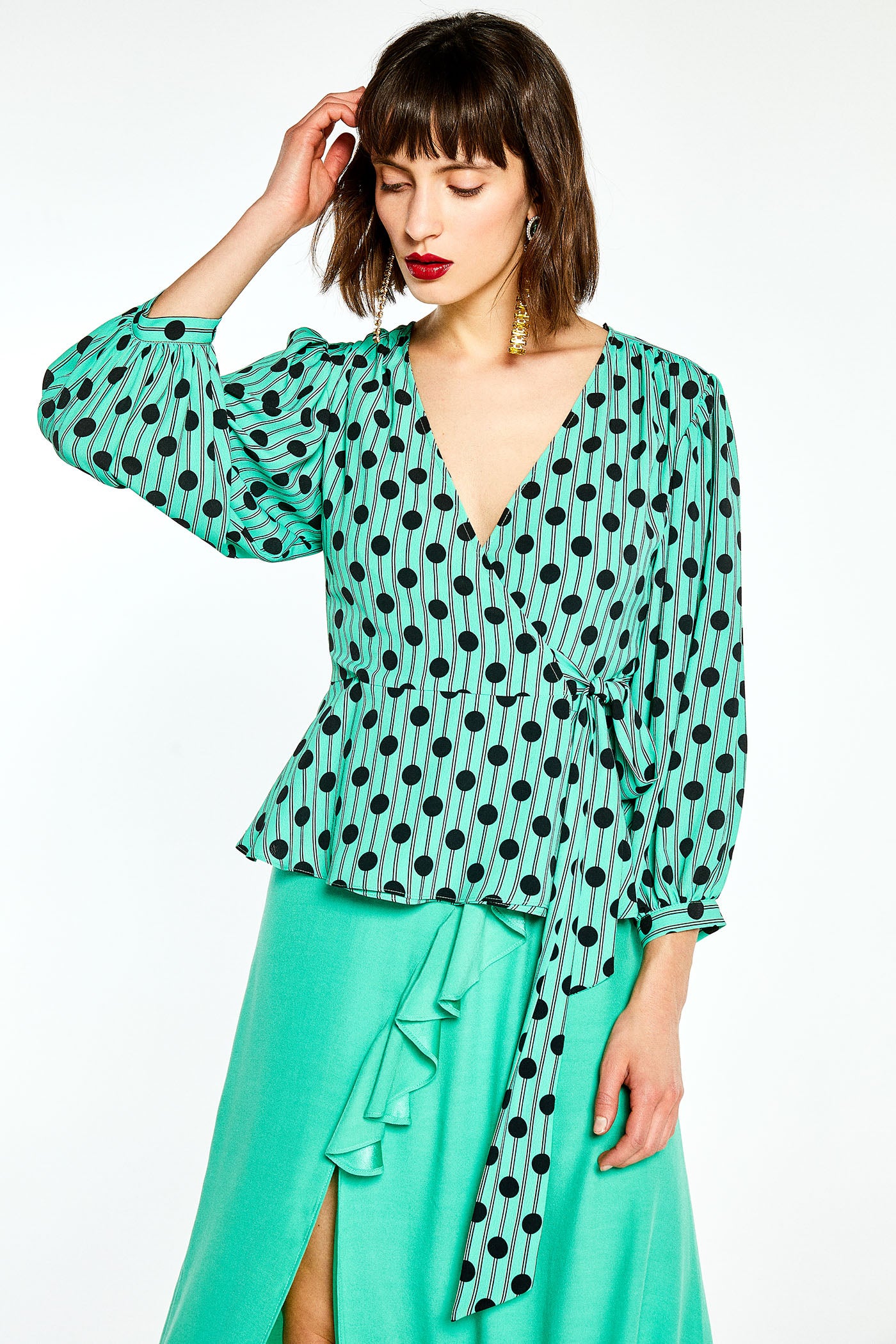 Blusa de lunares con lazada cruzada de Sfera: 19,99 euros.