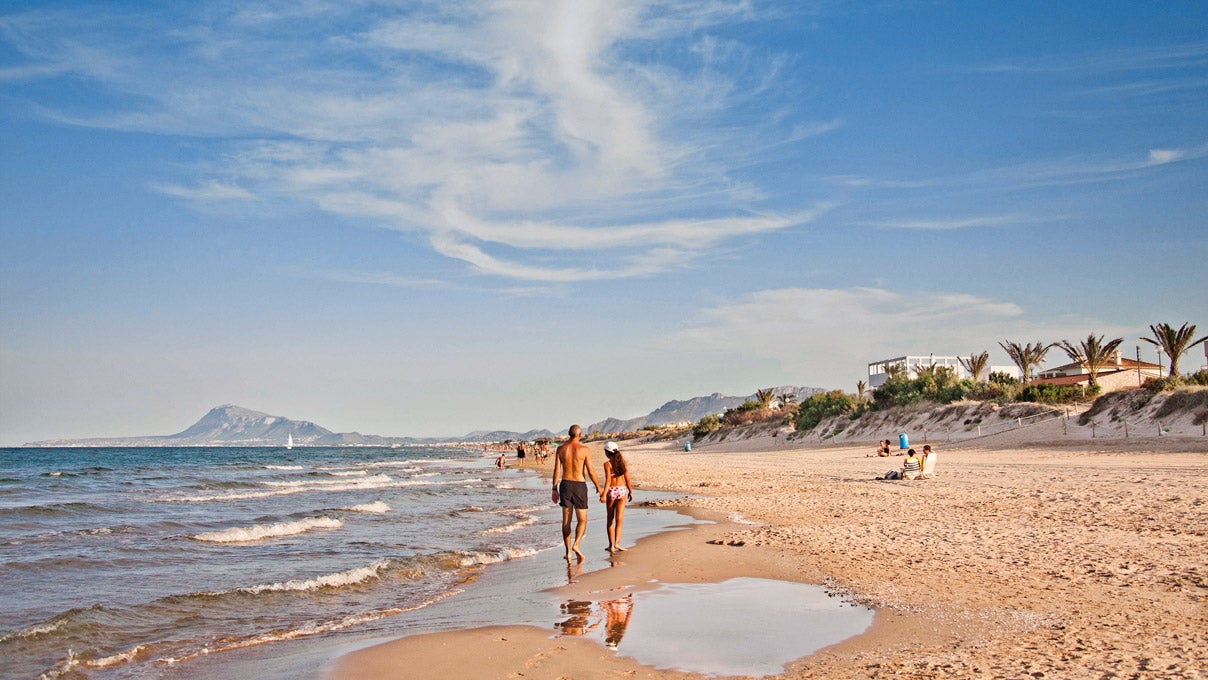 La playa de Aigua Blanca está situado en la localidad valenciana de Oliva. Se trata de una playa en la que podrás disfrutar de su arena dorada y fina mientras paseas en sus casi 2 kilómetros de longitud. Cuenta con un paseo marítimo y con numerosos chiringuitos pintorescos en los que tomar algo al atardecer.