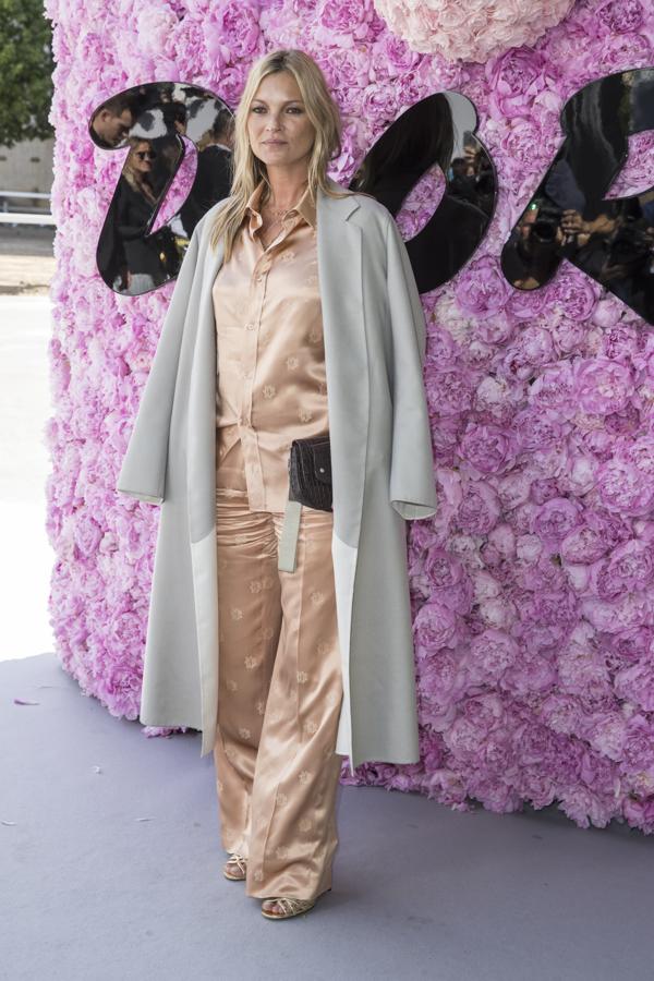 Kate Moss llevaba un conjunto de raso de estilo pijama que combinó con una gabardina sobre los hombros y una cartera de mano.