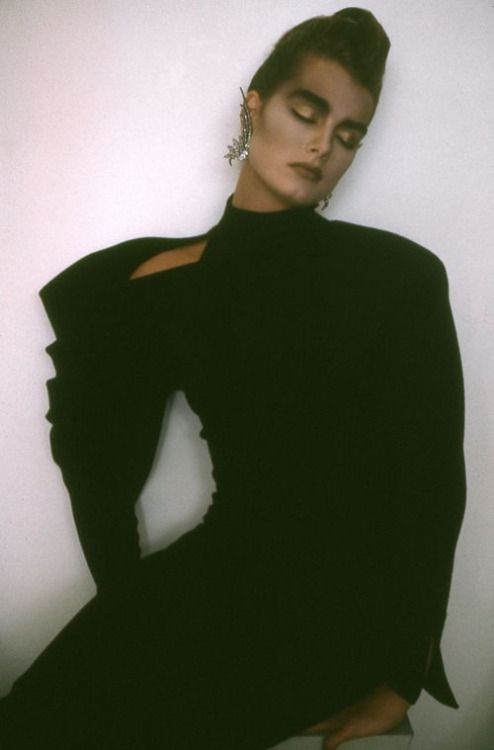 El vestido negro, con hombreras y cuello alto y ajustado al cuerpo fue otro 'hit' de aquellos maravillosos años. Aquí vemos a un jovencísima Brooke Shields, fotografiada por Sheila Metzner con un vestido de Claude Montana en 1985. El vestido negro y sinuoso se convirtió en mucho más que fondo de armario. Veamos más modelos de la época con variaciones sobre el mismo diseño.