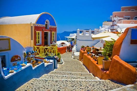 Eso sí, aunque el azul y el blanco sean los típicos de Santorini (como bien refleja la bandera griega), te enamorarás de sus rincones llenos de color. Un paseo por sus calles empedradas (ojo, deja los tacones en el hotel) será una auténtica explosión para tus sentidos.