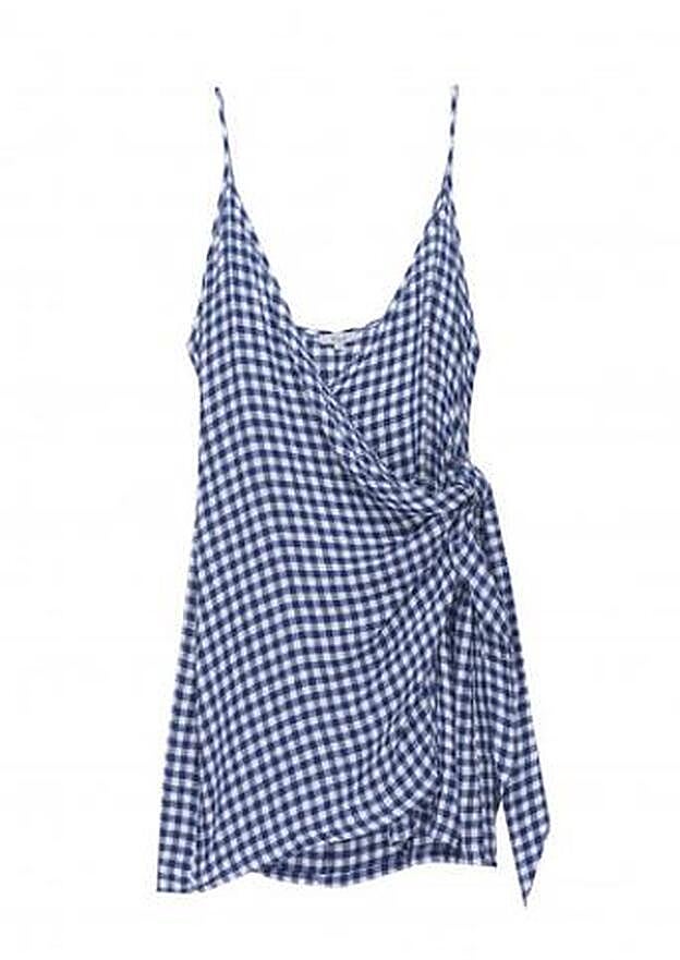 Minivestido cruzado con detalle de nudo y cuadros vichy en azul marino y blanco, unos 143 euros.