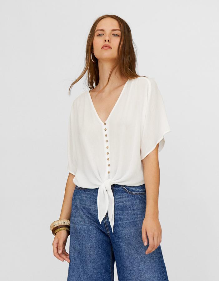 Camisa blanca con botones y detalle de nudo, 15,99 euros.
