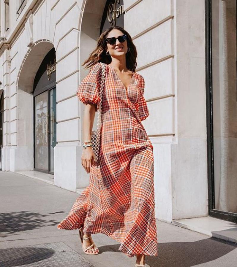 Con vestido de cuadros, de  Ganni  y bolso de cuentas.