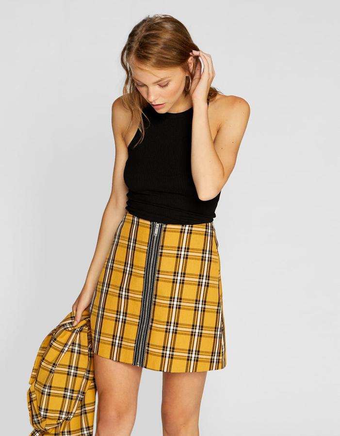Falda mini de cuadros con cremallera y en color mostaza, 15,99 euros.