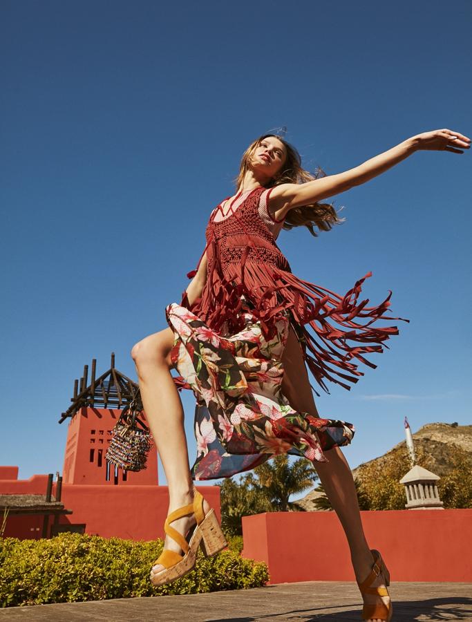 El top de flecos es de Zara; el vestido de flores, de Desigual; el bolso y el asa intercambiable, de Dior, y los zapatos, de Stonefly.