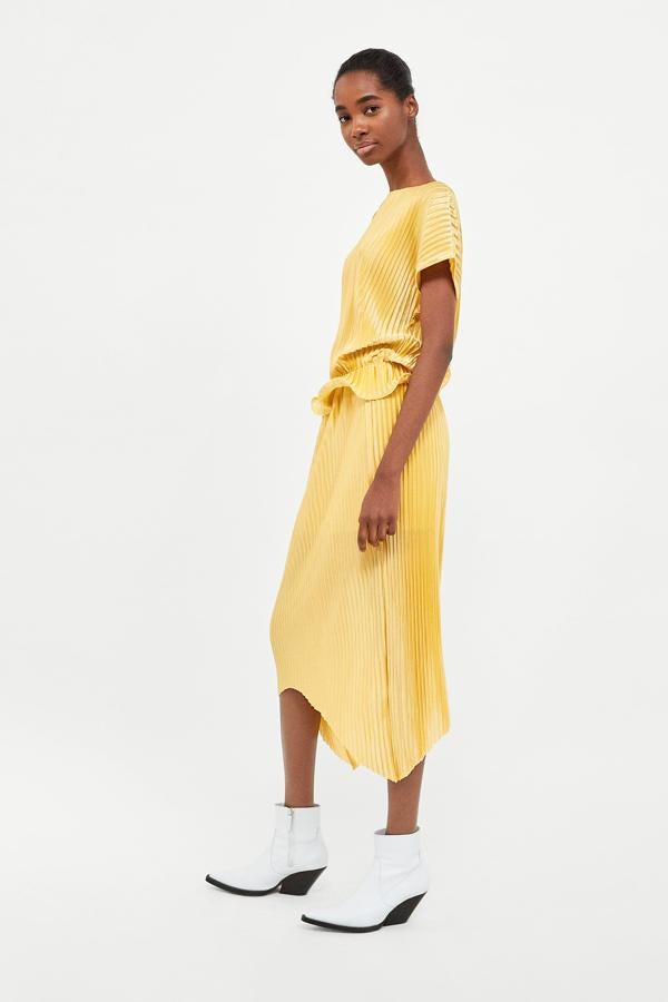 Plisada, amarilla y con largo midi asimétrico,  esta falda no puede ser más tendencia ... Su precio en las últimas rebajas de Zara pasa de 25.95 a 7.99 euros.